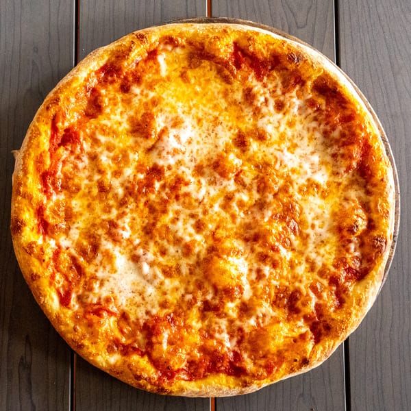 A perfectly baked cheese pizza with a golden crust sits on a dark wooden table.