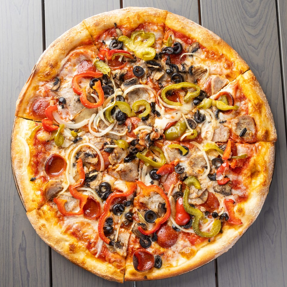 A whole pizza with pepperoni, sausage, mushrooms, onions, olives, and bell peppers.